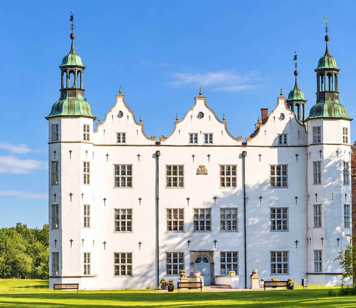 Das weiße Ahrensburger Schloss mit seinen markanten Türmen und dem grünen Schlosspark